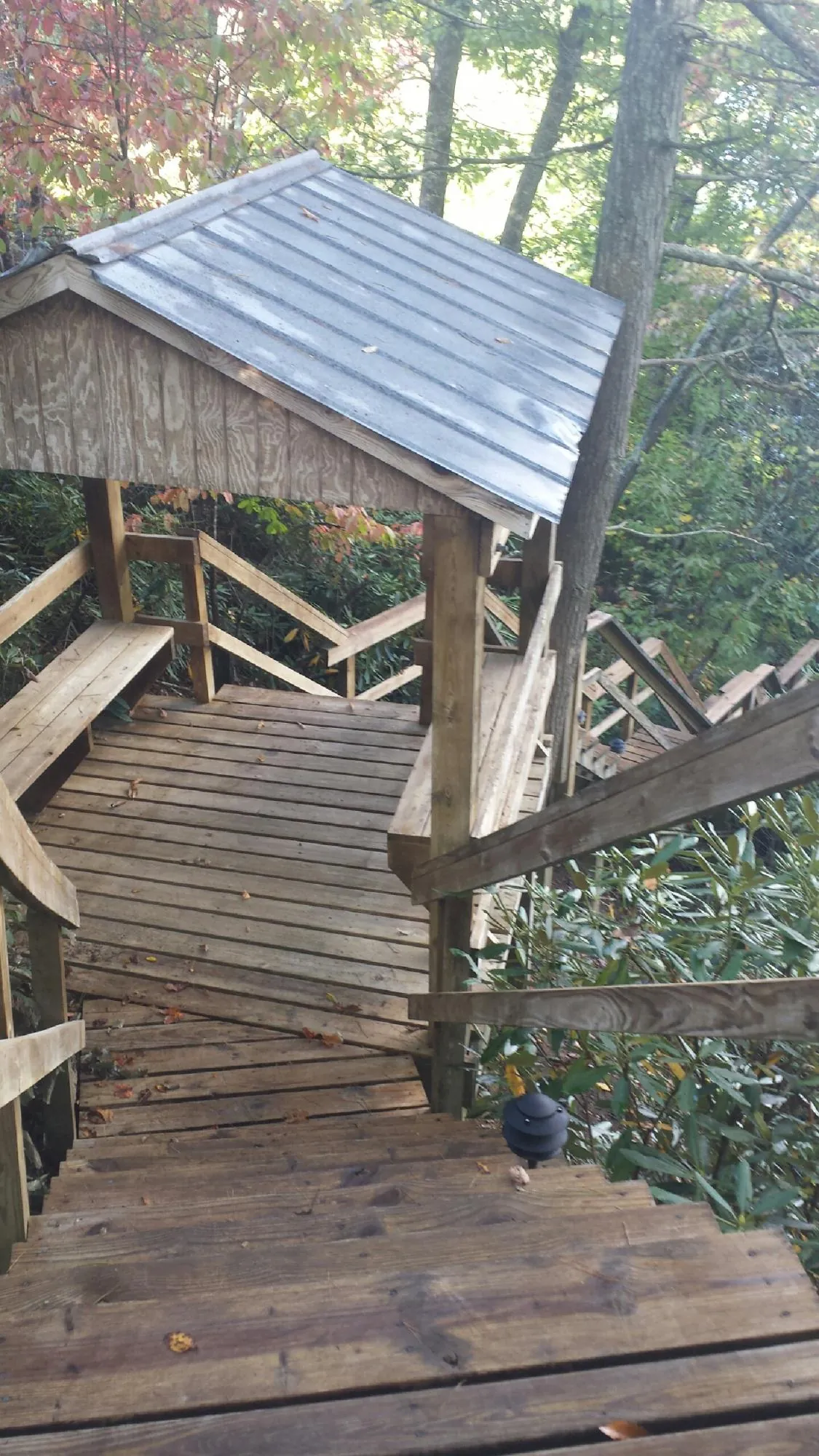 Metal roofed shelter over wooden steps on a wooded walkway — Skylight Repair & Installation work by our crew in Beallsville