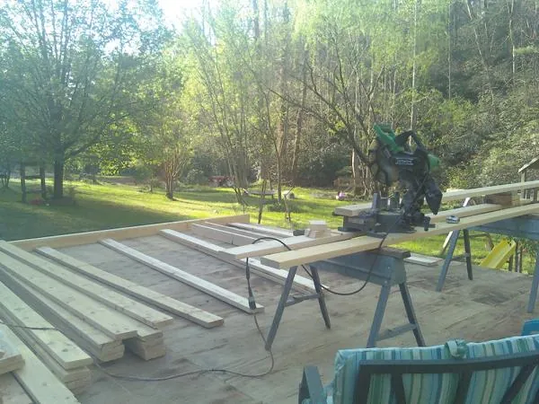 Miter saw and framing lumber on a deck under construction in Beallsville